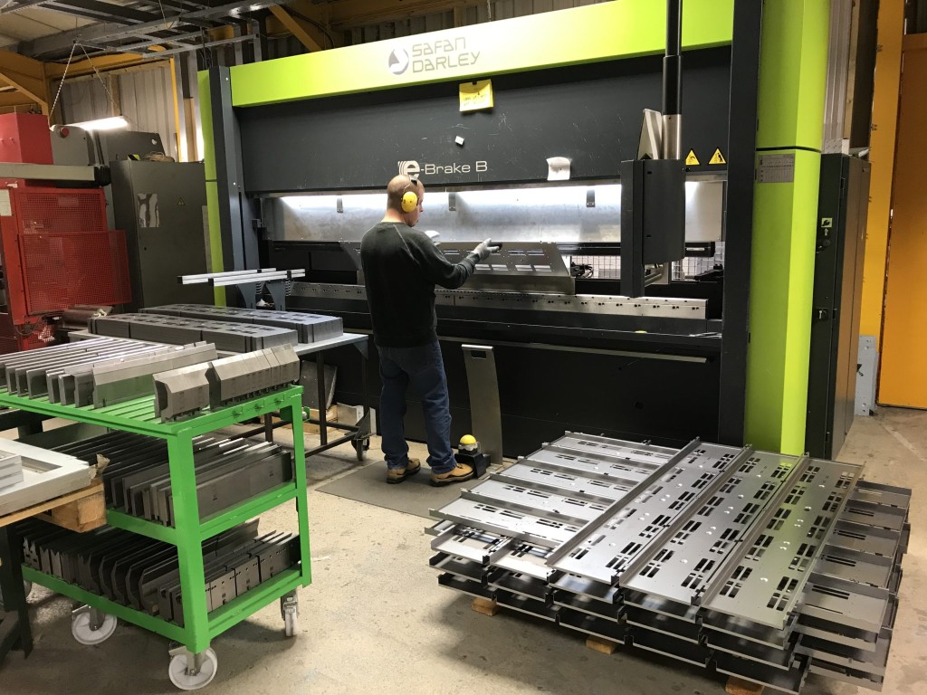 CNC press brake forming a sheet metal panel in the fabrication shop